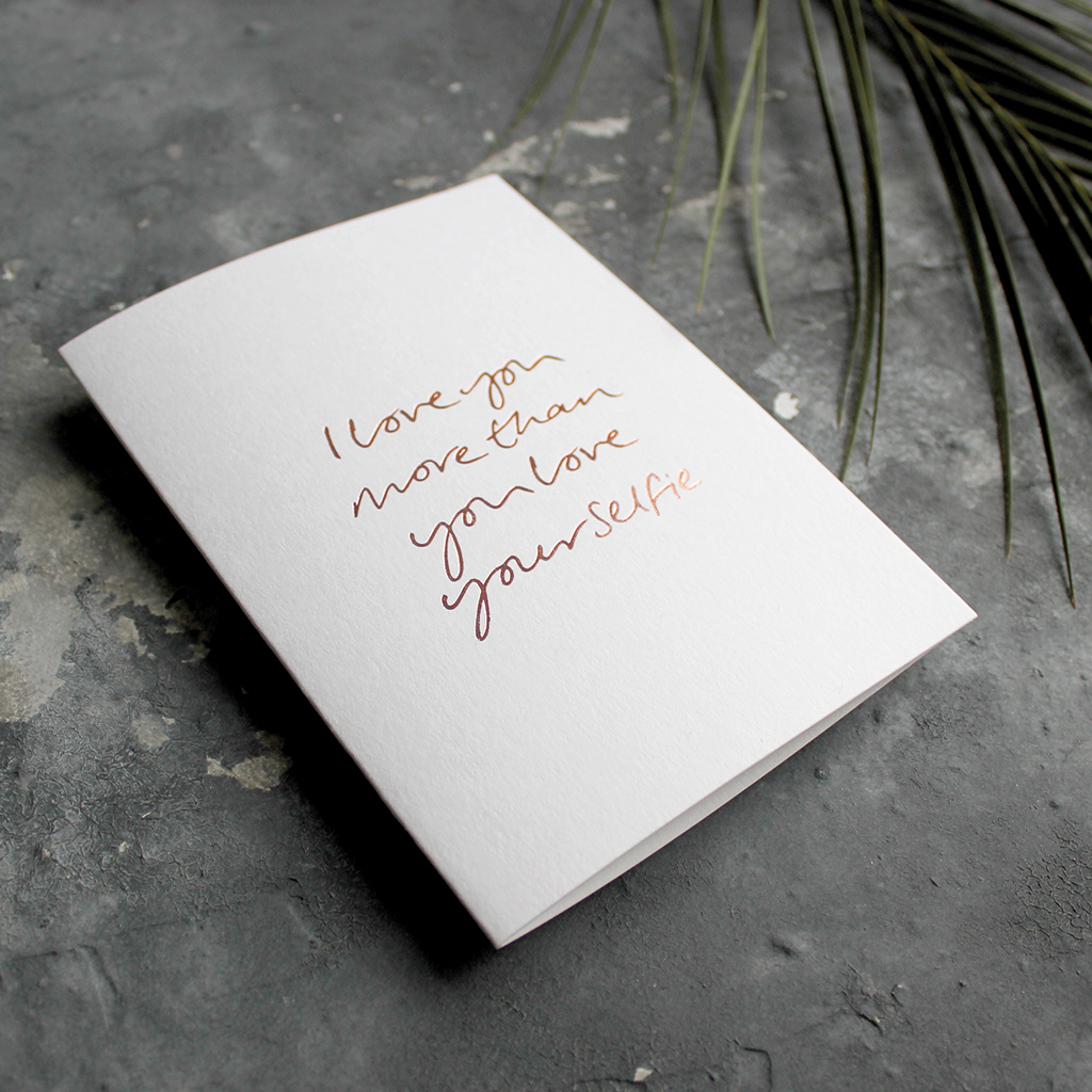 The front of this luxury card says I love you more than you love your selfie and is hand foiled in rose gold foil