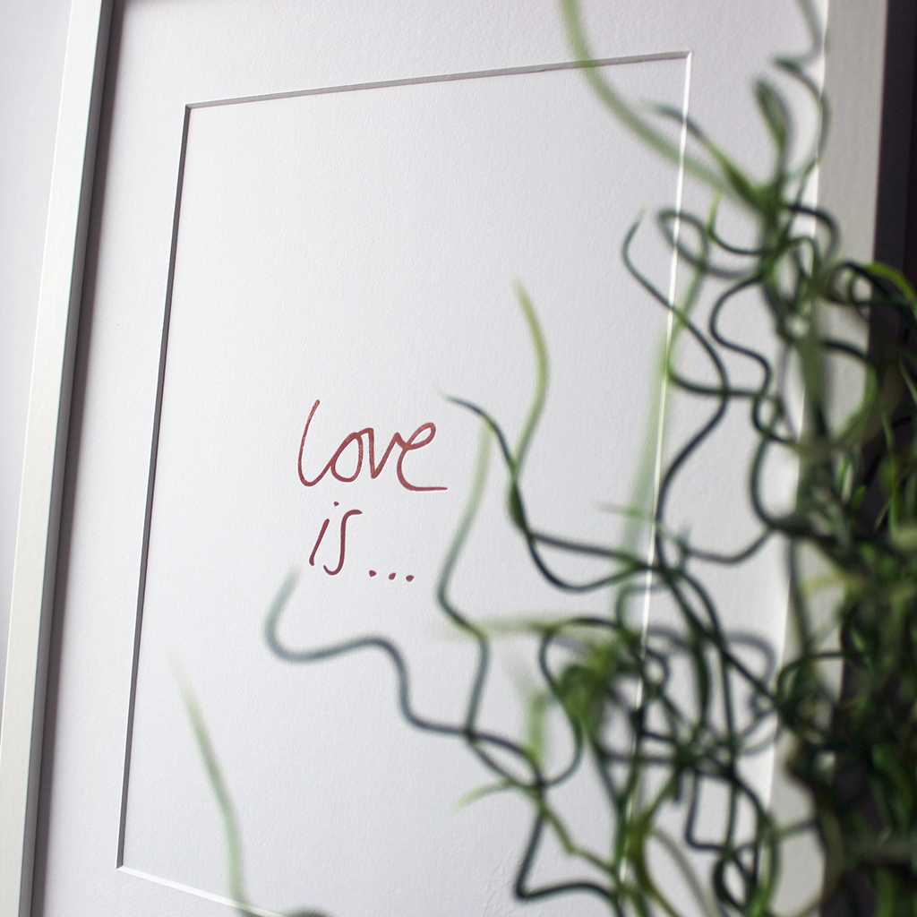 this handwritten Love Is... A4 print is hand pressed in rose gold foil and comes unframed