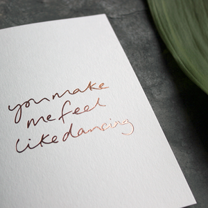 the handwritten words 'you make me feel like dancing' are hand foiled in rose gold on the front of the card